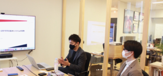 早稲田大学のラボで会話AIについて説明する松山先生と鈴木先生